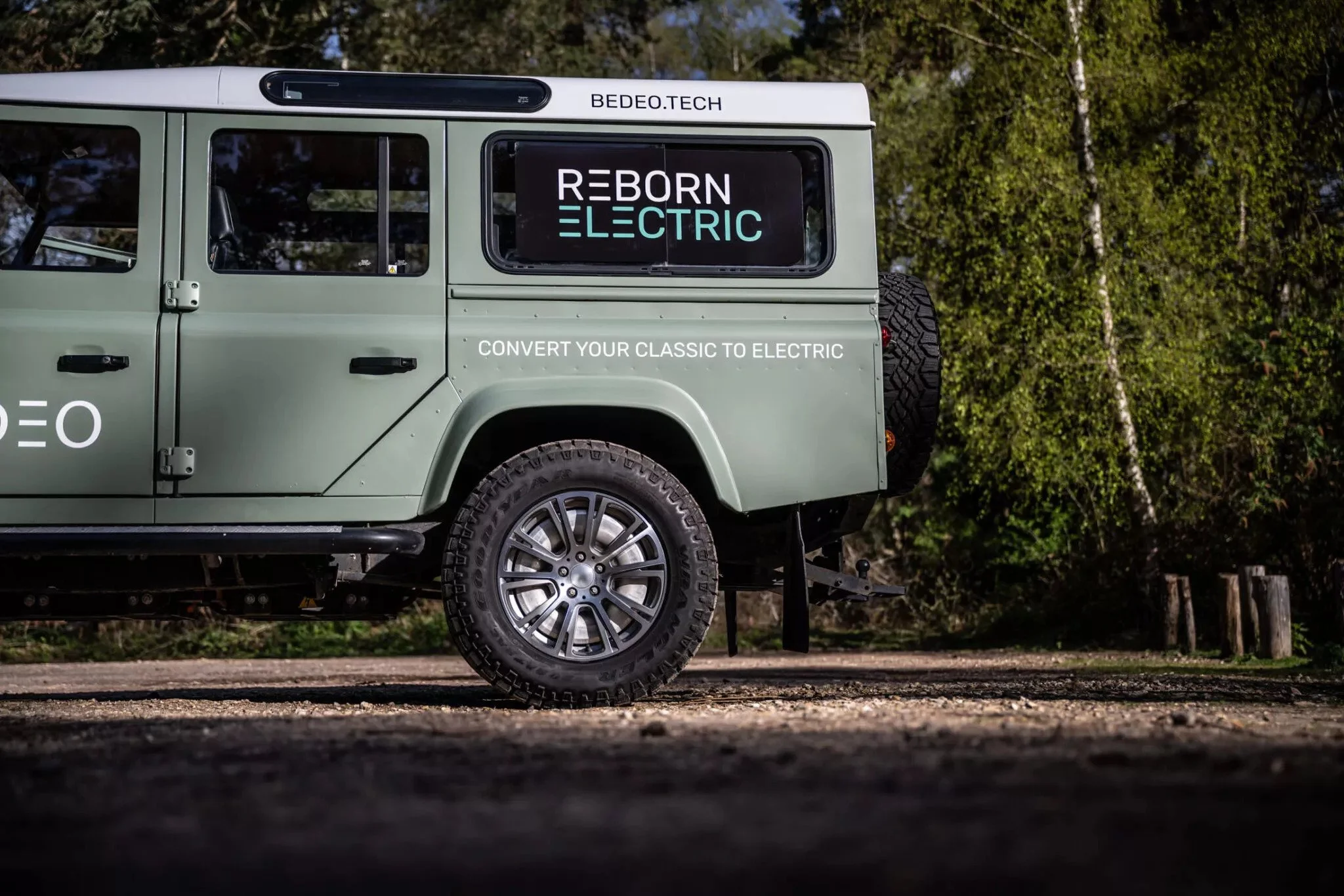 A converted Land Rover Defender in BEDEO livery, Reborn Electric on the rear window, convert your classic to electric along the body
