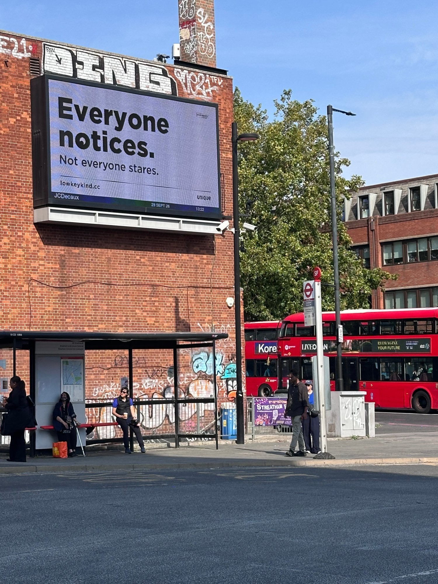 Low-key kind digital billboard above a bus stop in Streatham